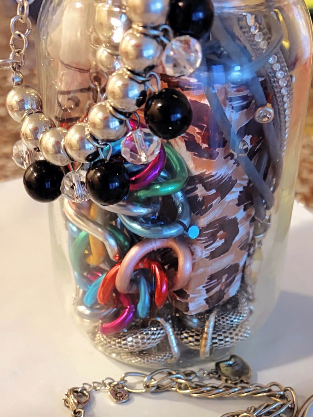 Jewelry Jar themed 80s with silver toned earrings, bracelet necklace and broch.